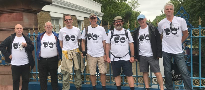 Group poses on a canal bridge. All wearing matching white t-shirts with the Headway logo.