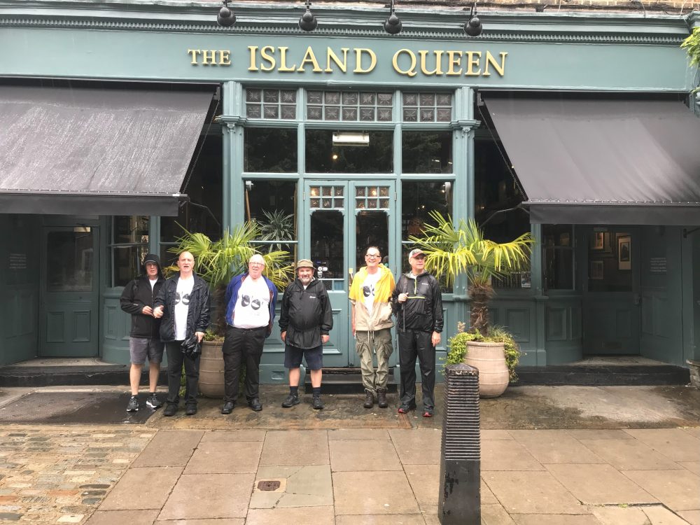 Group poses in front of pub named The Island Queen