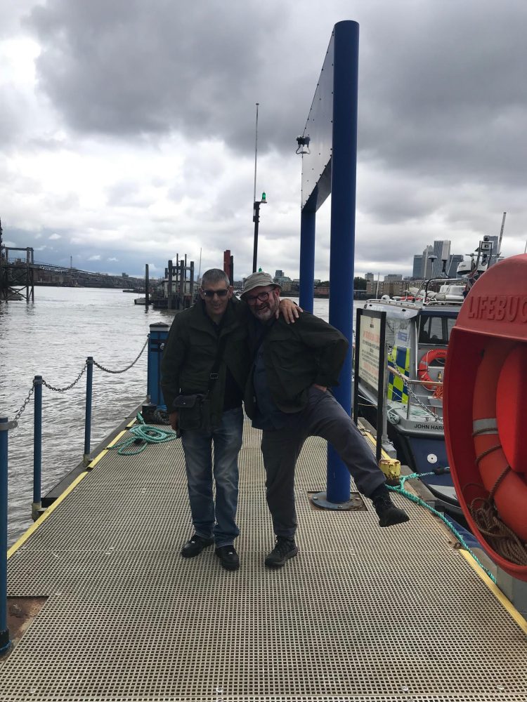 Two men on pontoon dock with arms around each other