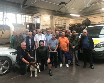 Group poses with police officers and sniffer dog