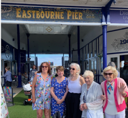 Group pose on Eastbourne Pier in summer clothes.