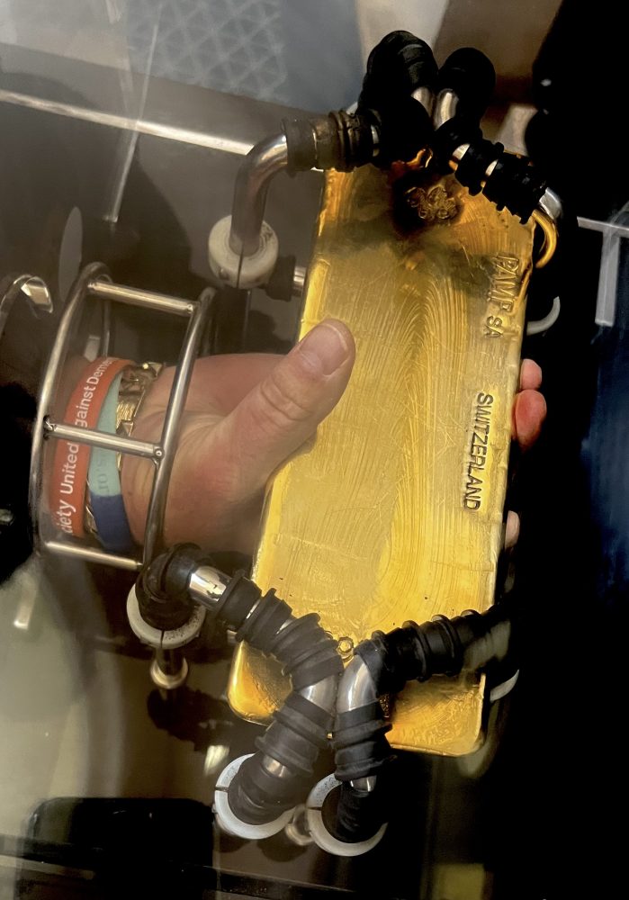 Close up photo of a Geezer holding a gold bar.